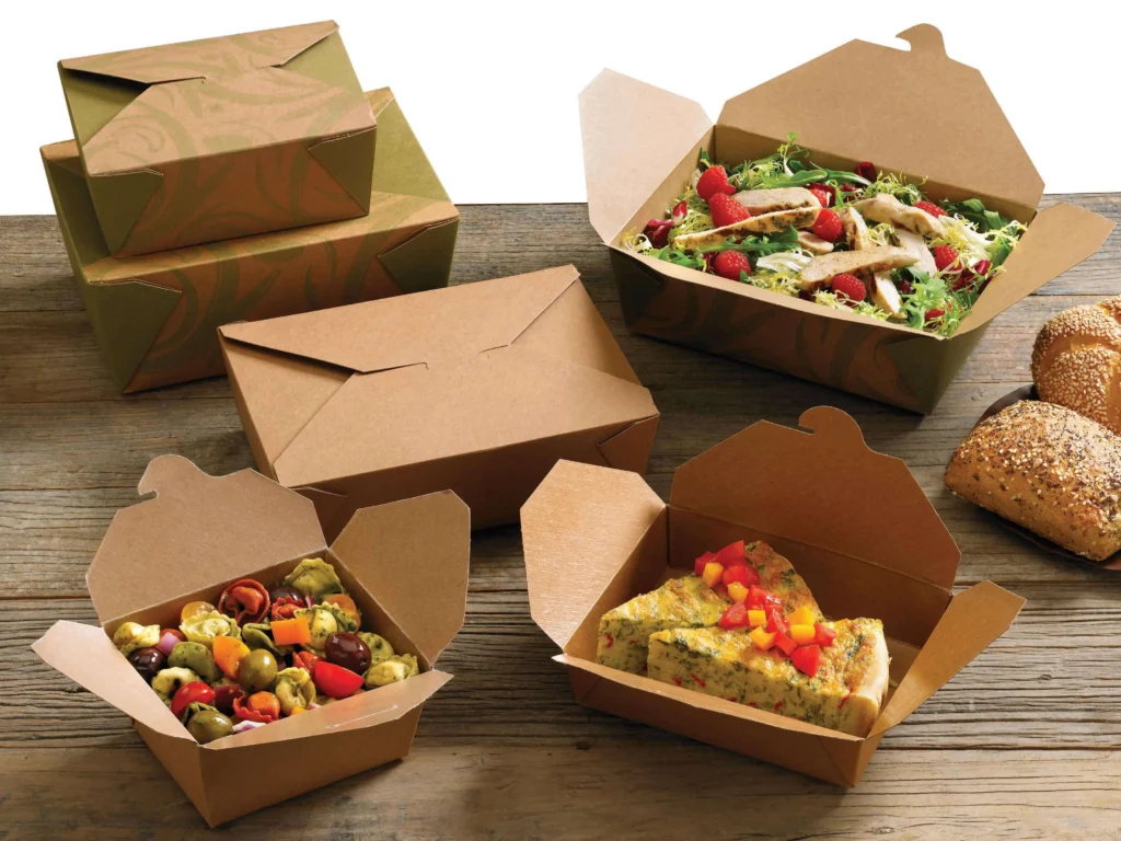 A table covered with an array of food items in cardboard boxes, emphasizing the practicality of food packaging options.