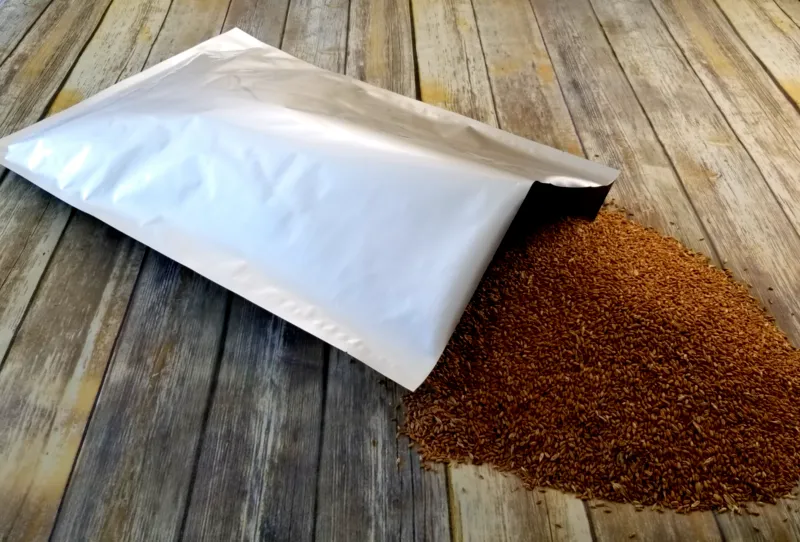 A mylar bag of brown rice placed on a wooden floor, showcasing its texture and packaging.